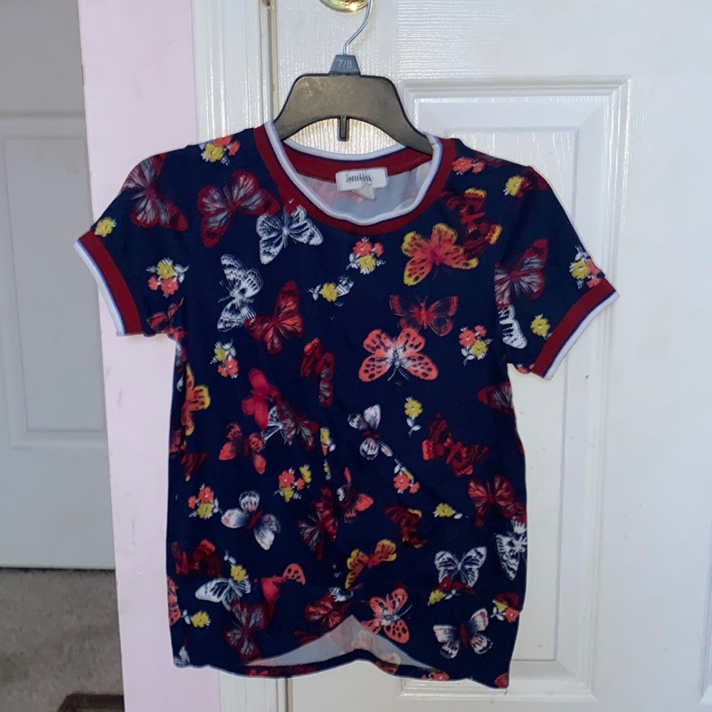 blue shirt with different colored butterflies on it